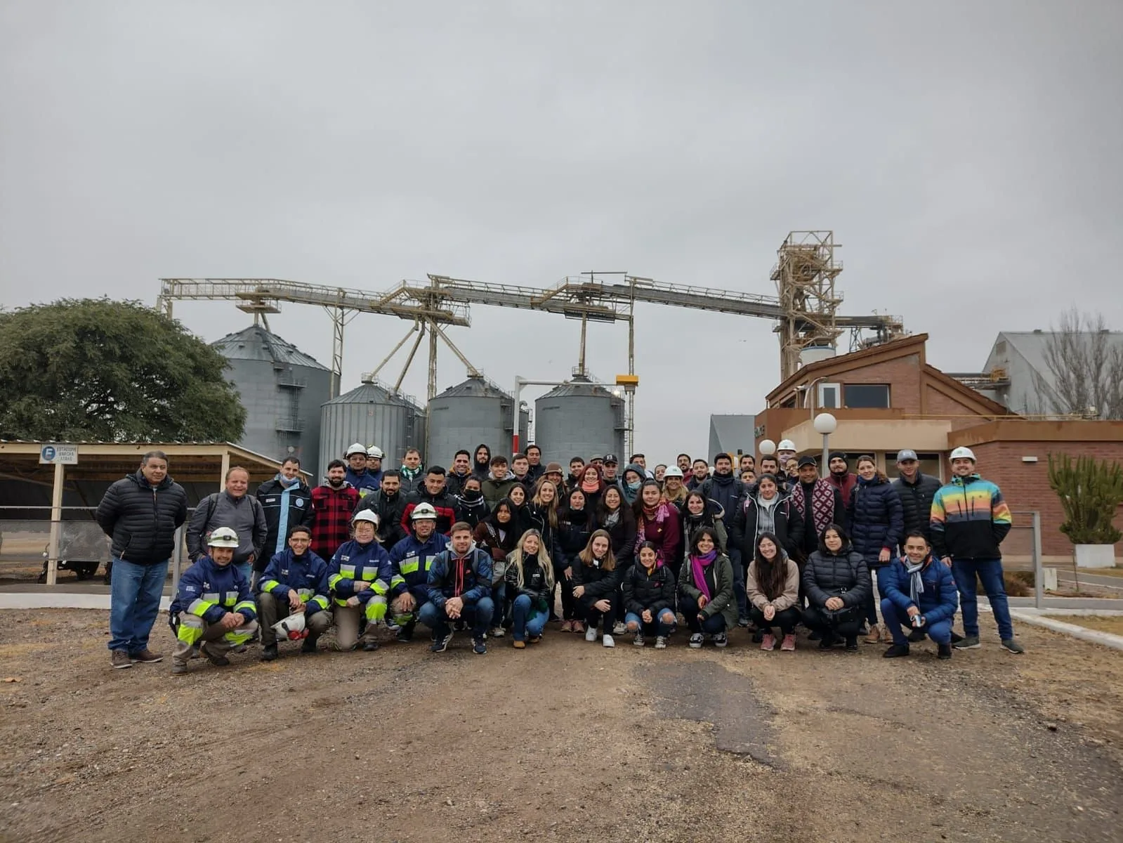 Grupo de estudiantes y docentes de Agro Escuela frente a los silos de una planta de acopio